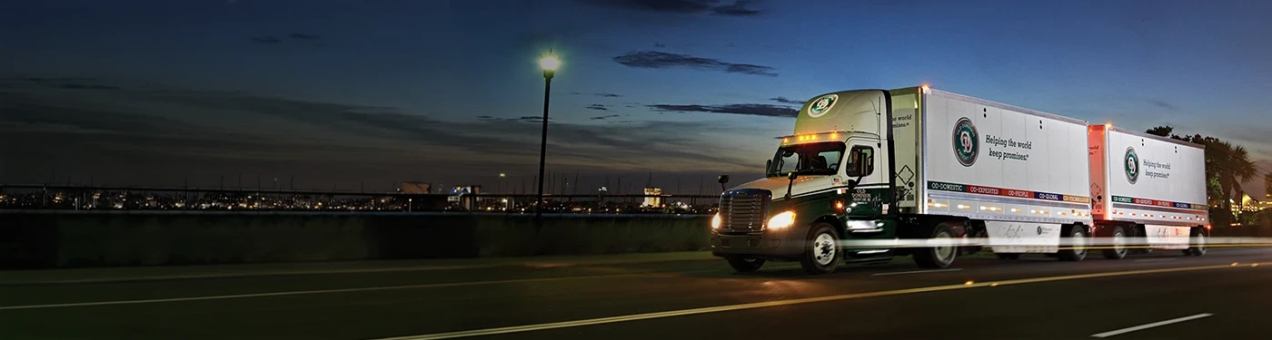 OD truck with pup trailers on highway at night